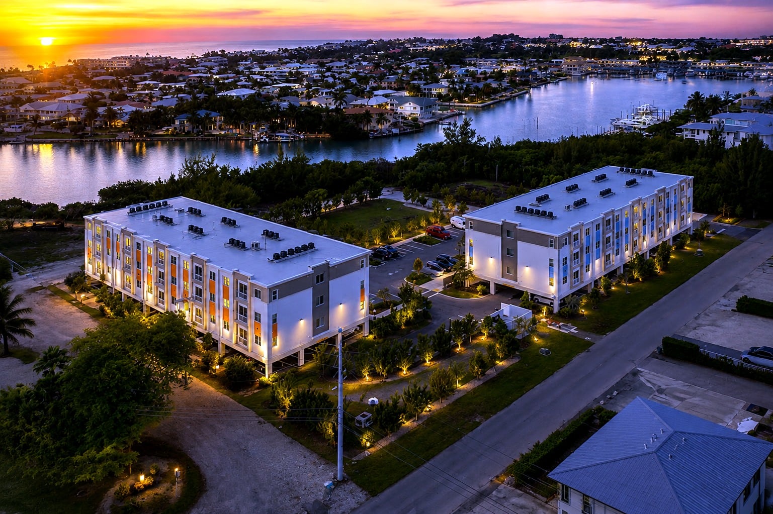 Coco Vista at dusk, both elevated apartment buildings and the Marathon waterfront behind