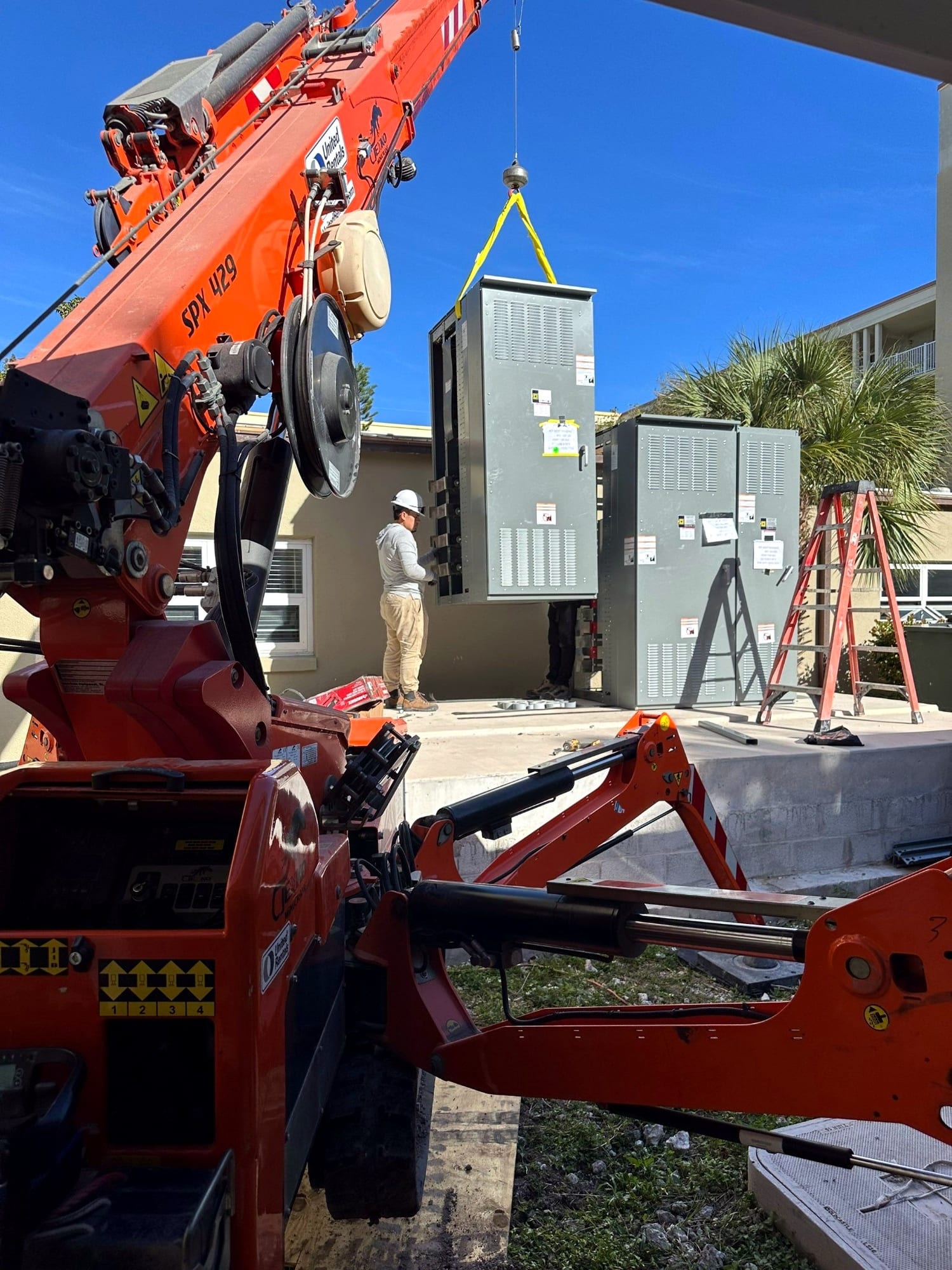 Crane setting outdoor switchgear into place