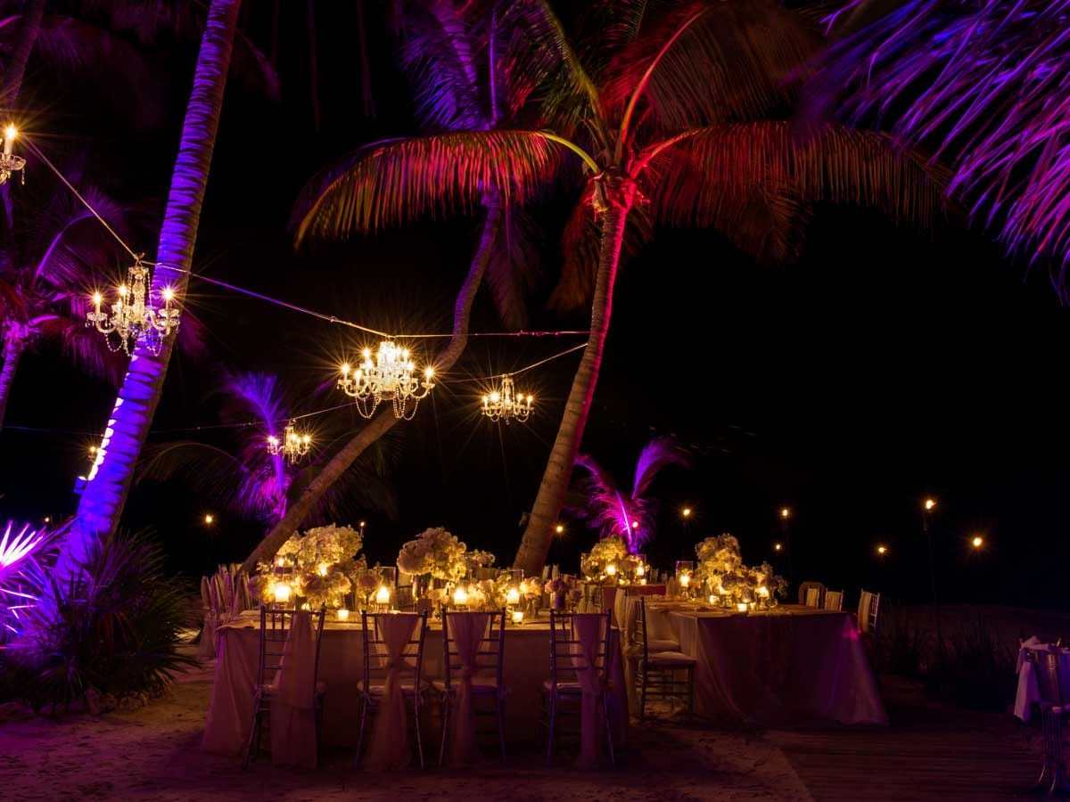 Evening dining setup at Little Palm Island lit by chandeliers and string lighting