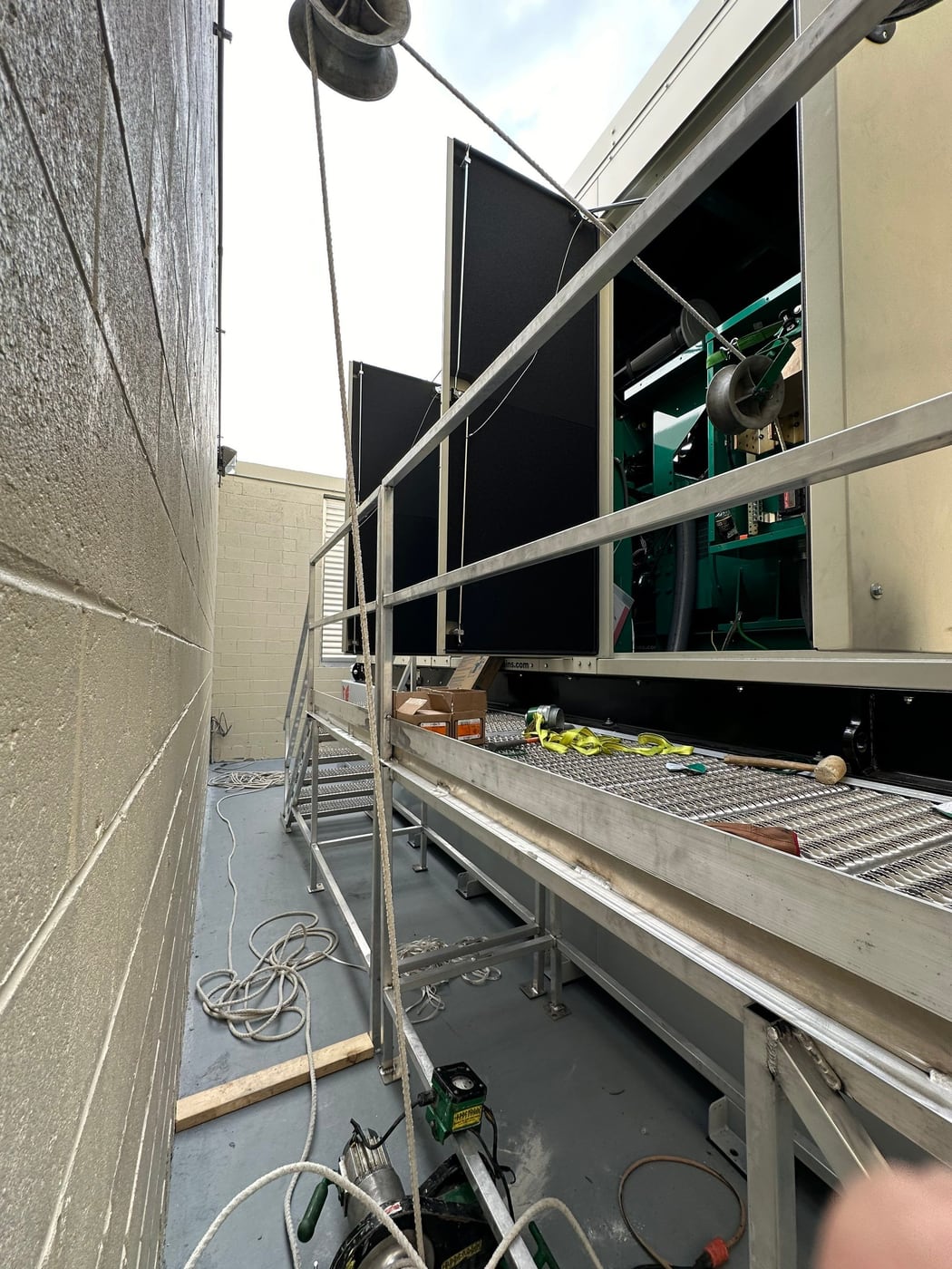 Generator being set into place with scaffolding and rigging alongside