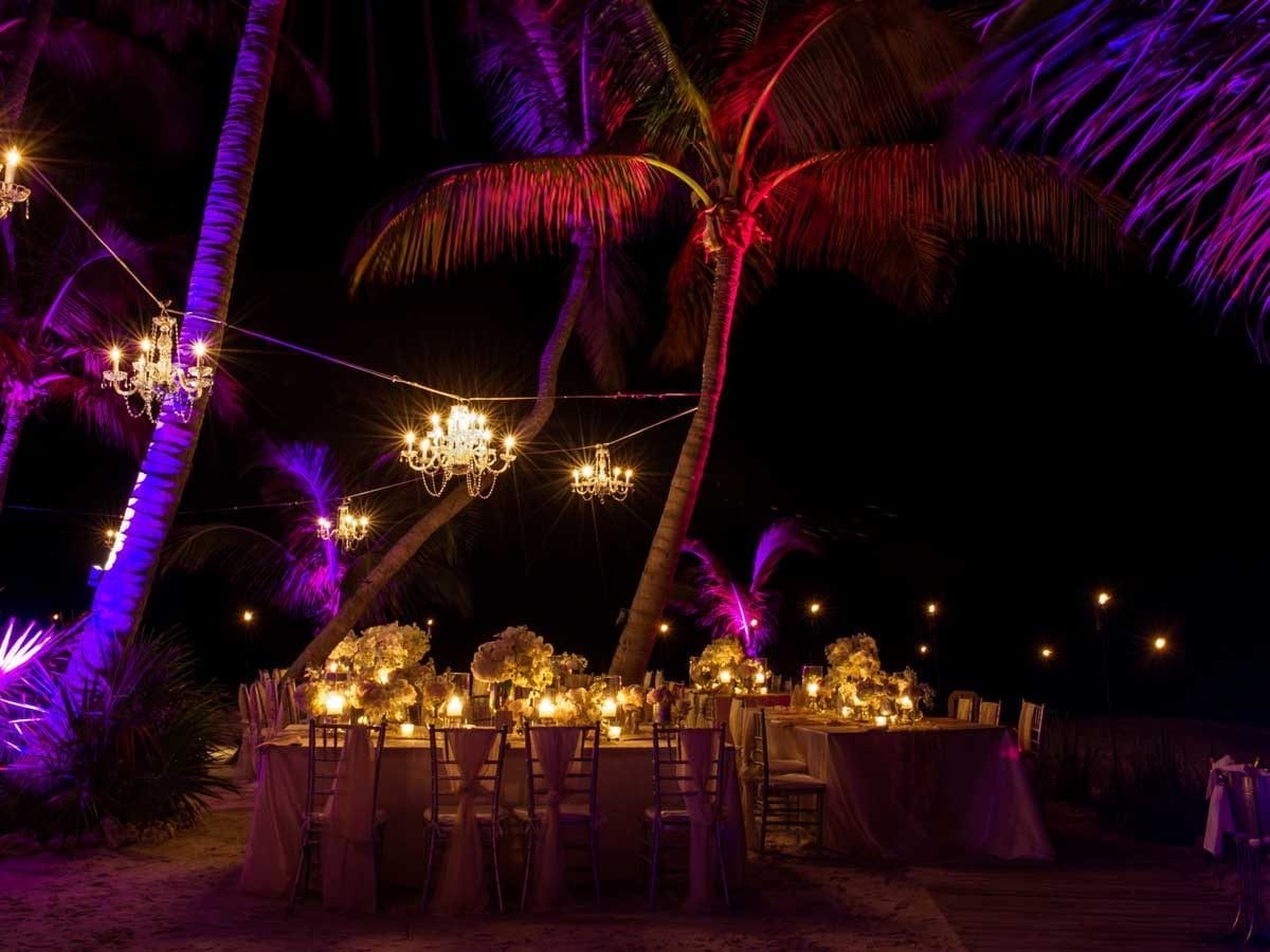 Evening dining setup at Little Palm Island lit by chandeliers and string lighting